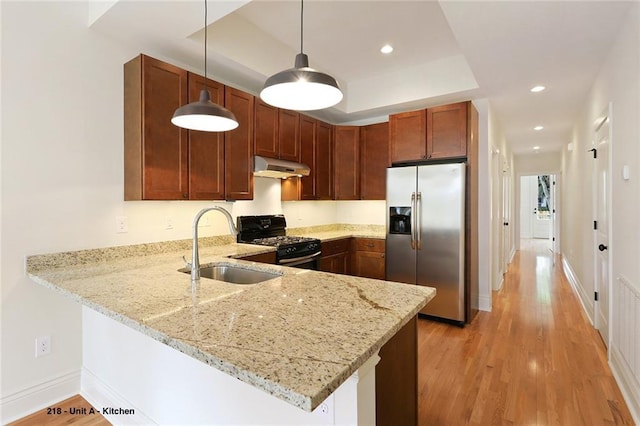218 S Gayoso St, New Orleans, LA 70119 - kitchen with stainless steel fridge with ice dispenser, gas range oven, under cabinet range hood, a sink, and a peninsula