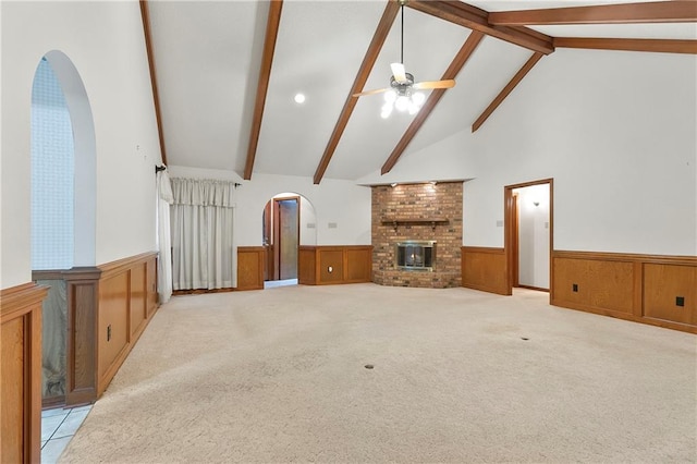 1 Fairfax Ct, Marrero, LA 70072 - unfurnished living room with a wainscoted wall, beam ceiling, a fireplace, arched walkways, and ceiling fan