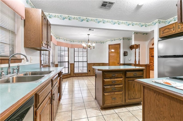 1 Fairfax Ct, Marrero, LA 70072 - kitchen with freestanding refrigerator, a sink, wallpapered walls, a textured ceiling, and wainscoting