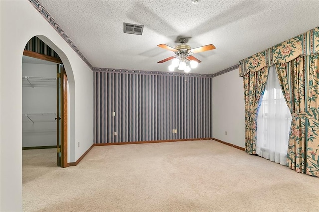1 Fairfax Ct, Marrero, LA 70072 - carpeted empty room with a ceiling fan, arched walkways, baseboards, and a textured ceiling