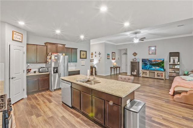 kitchen with stainless steel appliances, a sink, open floor plan, ceiling fan, and recessed lighting