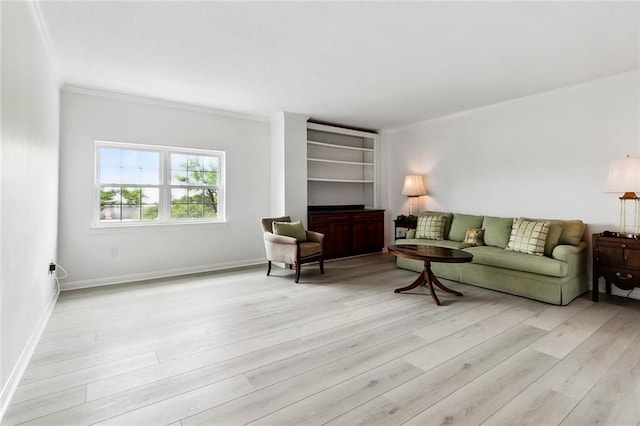 living area with crown molding, light wood-style floors, and baseboards