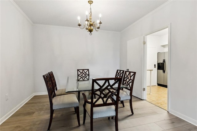 dining space featuring a chandelier, crown molding, baseboards, and light wood-style flooring