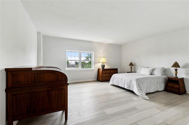 bedroom with light wood-style floors and baseboards