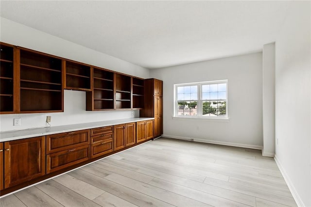 unfurnished office featuring light wood-style flooring and baseboards