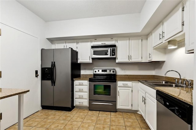 1750 Saint Charles Ave Unit 531, New Orleans, LA 70130 - kitchen with appliances with stainless steel finishes, a sink, white cabinets, dark stone counters, and light tile patterned floors