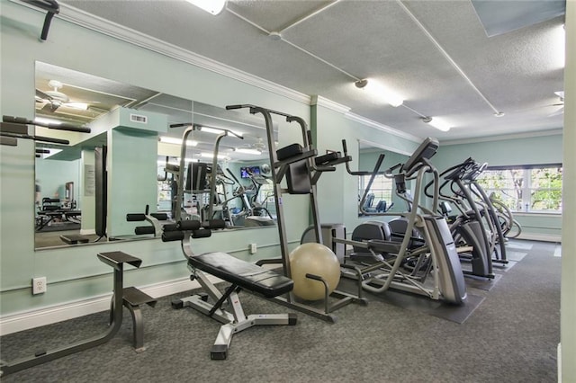 exercise room featuring ornamental molding, a textured ceiling, and carpet flooring