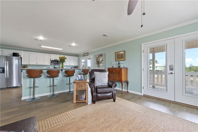 4102 Pennsylvania St, Bay Saint Louis, MS 39520 - sitting room featuring french doors, healthy amount of natural light, wood finished floors, a ceiling fan, and ornamental molding