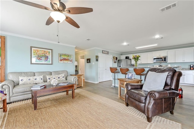 4102 Pennsylvania St, Bay Saint Louis, MS 39520 - living area with crown molding, light wood finished floors, a ceiling fan, baseboards, and recessed lighting
