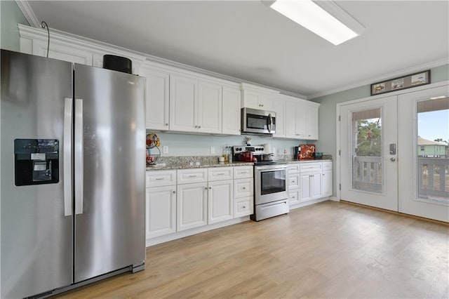4102 Pennsylvania St, Bay Saint Louis, MS 39520 - kitchen featuring appliances with stainless steel finishes, ornamental molding, white cabinets, and light wood-style floors
