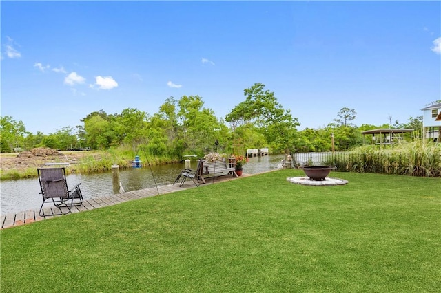 4102 Pennsylvania St, Bay Saint Louis, MS 39520 - view of green lawn with an outdoor fire pit, a boat dock, and a water view