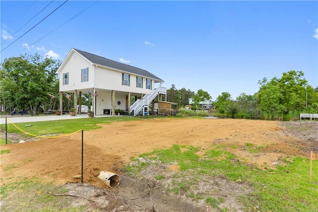4102 Pennsylvania St, Bay Saint Louis, MS 39520 - back of property featuring a carport, stairway, and dirt driveway