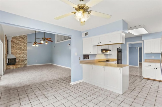 kitchen featuring black appliances, ceiling fan, a wood stove, light countertops, and white cabinetry
