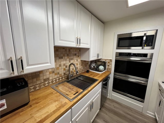 3278 Glen Eagle Ln, Kenner, LA 70065 - kitchen with appliances with stainless steel finishes, a sink, butcher block counters, white cabinets, and wood finished floors