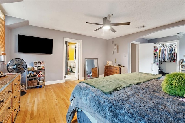 3931 S Post Oak Ave, New Orleans, LA 70131 - bedroom featuring light wood-style floors, arched walkways, baseboards, ceiling fan, and a spacious closet