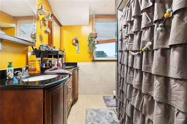 3931 S Post Oak Ave, New Orleans, LA 70131 - full bathroom featuring tile walls, vanity, a shower with shower curtain, and wainscoting
