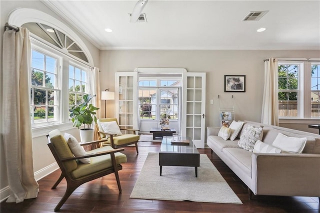 living area with dark wood-style floors, crown molding, and baseboards