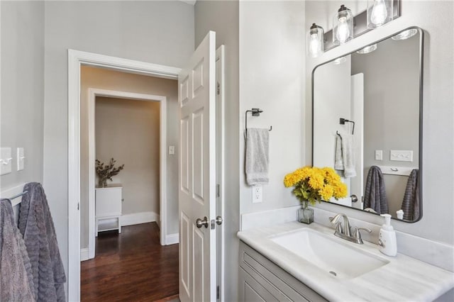 bathroom featuring wood finished floors, vanity, and baseboards