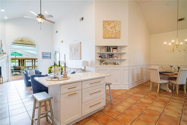 1413 Royal Palm Dr Unit A, Slidell, LA 70458 - kitchen with high vaulted ceiling, a kitchen bar, a chandelier, white cabinets, and a ceiling fan