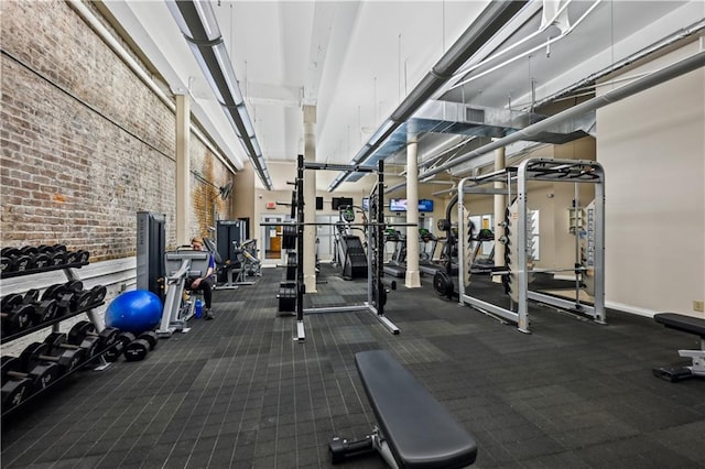 920 Poeyfarre St Unit 109, New Orleans, LA 70130 - exercise room featuring a high ceiling and brick wall
