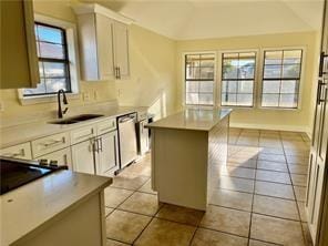 35 Derek Ln, La Place, LA 70068 - kitchen featuring dishwasher, a sink, a kitchen island, white cabinets, and vaulted ceiling