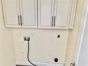 35 Derek Ln, La Place, LA 70068 - washroom with electric dryer hookup, hookup for a washing machine, baseboards, and cabinet space