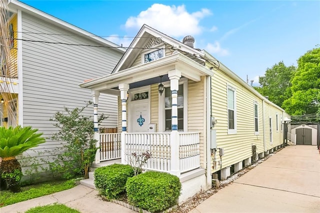 525 S Telemachus St, New Orleans, LA 70119 - shotgun-style home with a porch, a storage unit, and an outbuilding