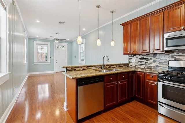 525 S Telemachus St, New Orleans, LA 70119 - kitchen with appliances with stainless steel finishes, a sink, crown molding, wood finished floors, and backsplash