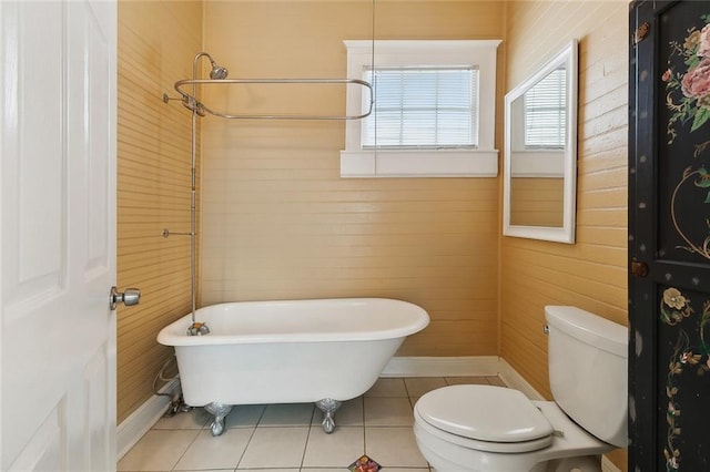 525 S Telemachus St, New Orleans, LA 70119 - bathroom featuring toilet, a freestanding bath, tile patterned flooring, wood walls, and baseboards