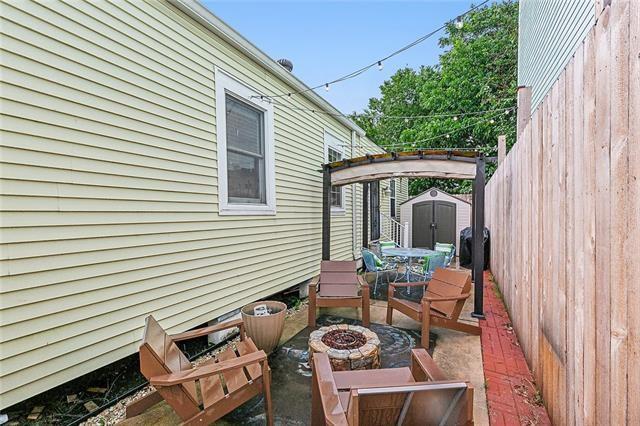 525 S Telemachus St, New Orleans, LA 70119 - view of patio / terrace featuring a storage unit, an outdoor fire pit, an outdoor structure, and fence