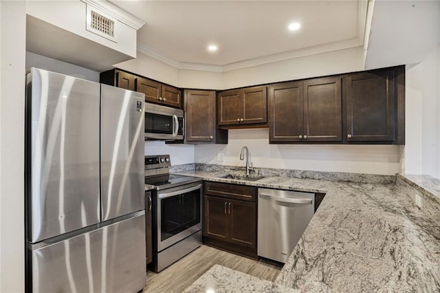 500 Lake Marina Ave Unit 408, New Orleans, LA 70124 - kitchen featuring appliances with stainless steel finishes, dark brown cabinets, light stone counters, light wood-style floors, and crown molding