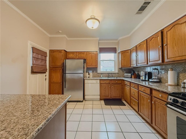 28 San Jose Ave, Jefferson, LA 70121 - kitchen featuring stainless steel appliances, a sink, tasteful backsplash, brown cabinetry, and crown molding