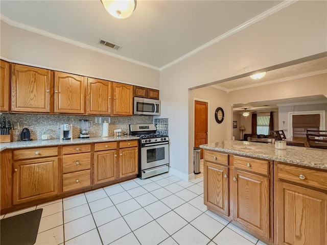 28 San Jose Ave, Jefferson, LA 70121 - kitchen with stainless steel appliances, light tile patterned floors, ornamental molding, brown cabinetry, and tasteful backsplash