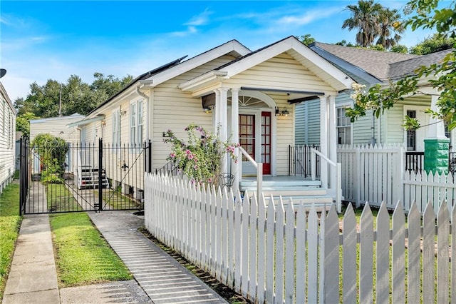 2437 Jonquil St, New Orleans, LA 70122 - shotgun-style home with a gate, a porch, and a fenced front yard