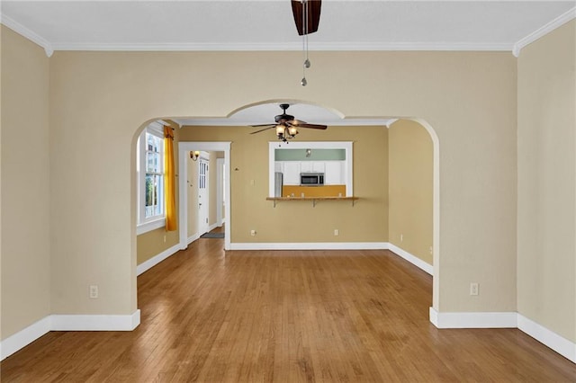 2437 Jonquil St, New Orleans, LA 70122 - spare room with a ceiling fan, arched walkways, crown molding, wood finished floors, and baseboards