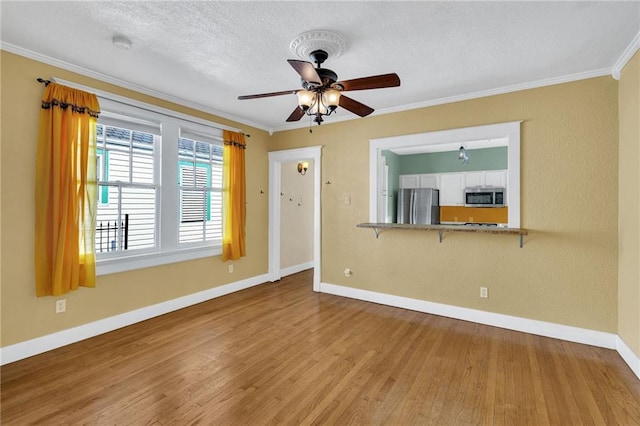 2437 Jonquil St, New Orleans, LA 70122 - unfurnished living room with baseboards, crown molding, wood finished floors, ceiling fan, and a textured ceiling