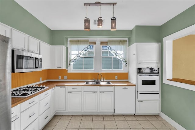 2437 Jonquil St, New Orleans, LA 70122 - kitchen with stainless steel appliances, a sink, white cabinetry, and light countertops