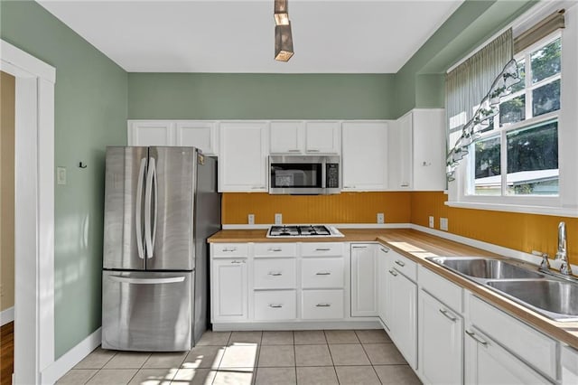 2437 Jonquil St, New Orleans, LA 70122 - kitchen featuring appliances with stainless steel finishes, a sink, plenty of natural light, and white cabinets