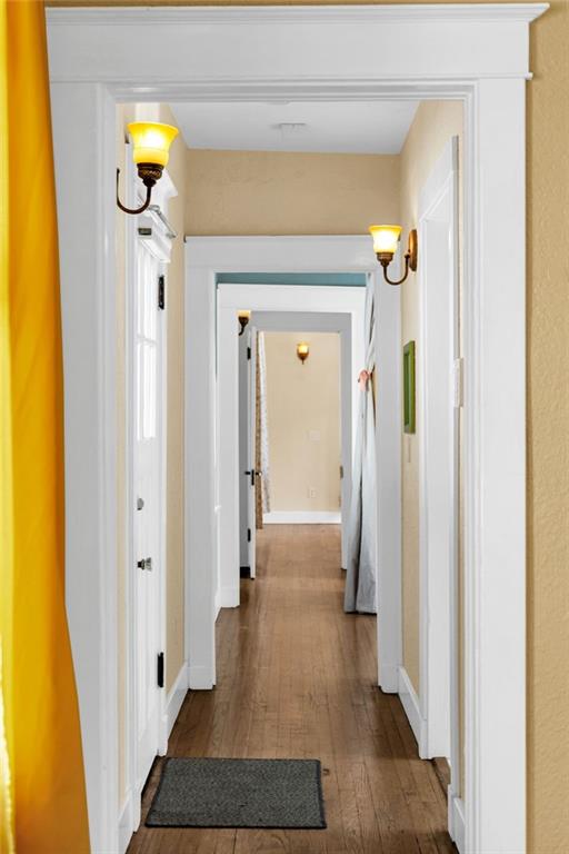 2437 Jonquil St, New Orleans, LA 70122 - hallway featuring dark wood-type flooring and baseboards