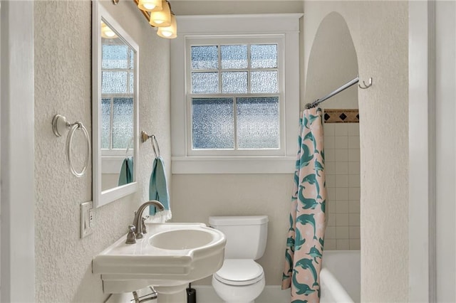 2437 Jonquil St, New Orleans, LA 70122 - bathroom with a textured wall, toilet, shower / bath combo, and a sink