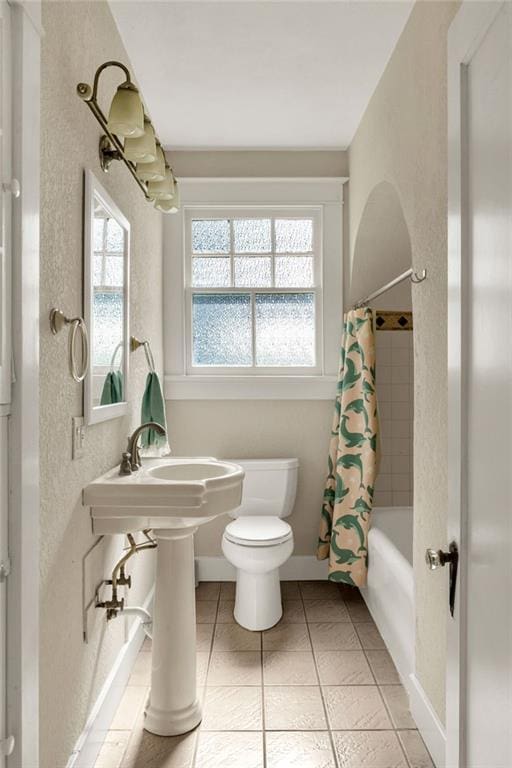 2437 Jonquil St, New Orleans, LA 70122 - bathroom featuring toilet, tile patterned flooring, shower / tub combo with curtain, and a textured wall