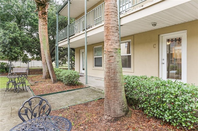 view of yard featuring a balcony, fence, and a patio