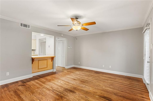 unfurnished bedroom featuring baseboards, crown molding, light wood finished floors, connected bathroom, and a ceiling fan