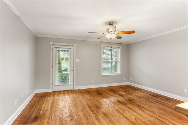 empty room featuring wood finished floors, a ceiling fan, baseboards, and ornamental molding