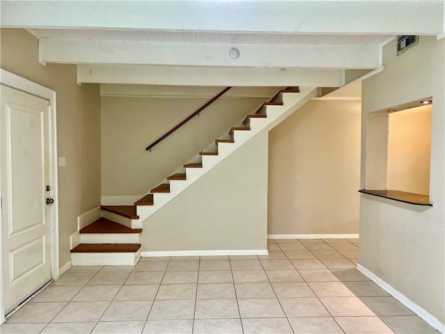 204 W 11th Ave Unit 4, Covington, LA 70433 - finished below grade area with stairs, light tile patterned floors, and baseboards