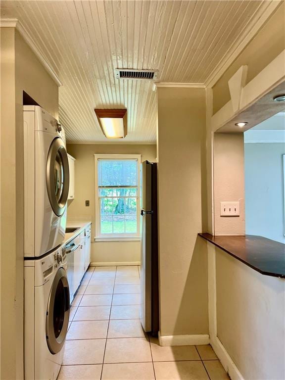204 W 11th Ave Unit 4, Covington, LA 70433 - clothes washing area featuring stacked washer and clothes dryer, wood ceiling, light tile patterned floors, ornamental molding, and baseboards