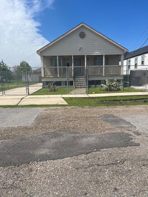 view of front of home with covered porch, fence, and a gate