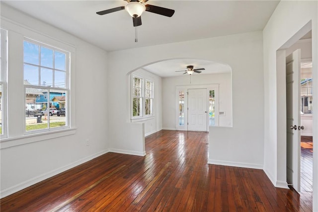 1225 S Genois St, New Orleans, LA 70125 - empty room featuring arched walkways, a ceiling fan, hardwood / wood-style flooring, and plenty of natural light