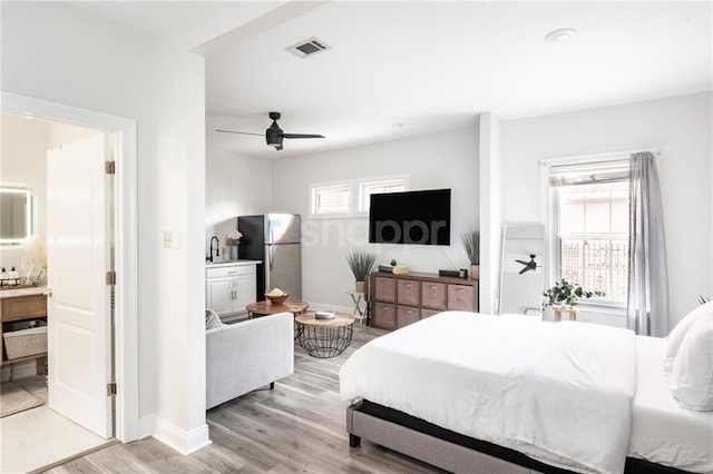2522 Robert St, New Orleans, LA 70115 - bedroom featuring freestanding refrigerator, light wood-style floors, baseboards, connected bathroom, and a ceiling fan