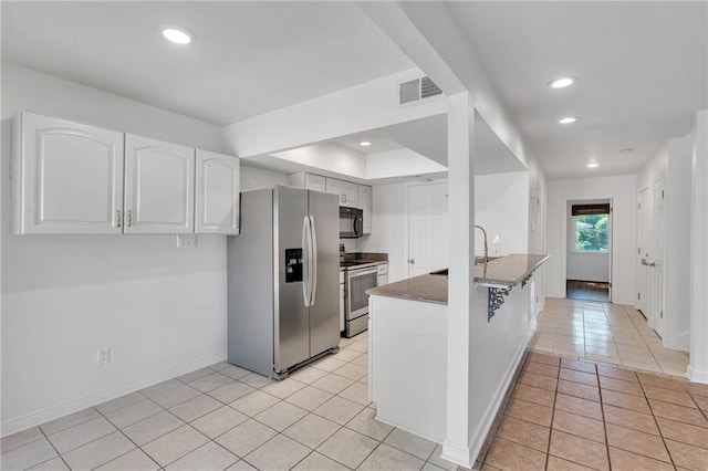 343 Lake Ave, Metairie, LA 70005 - kitchen with appliances with stainless steel finishes, light tile patterned floors, white cabinetry, baseboards, and a peninsula